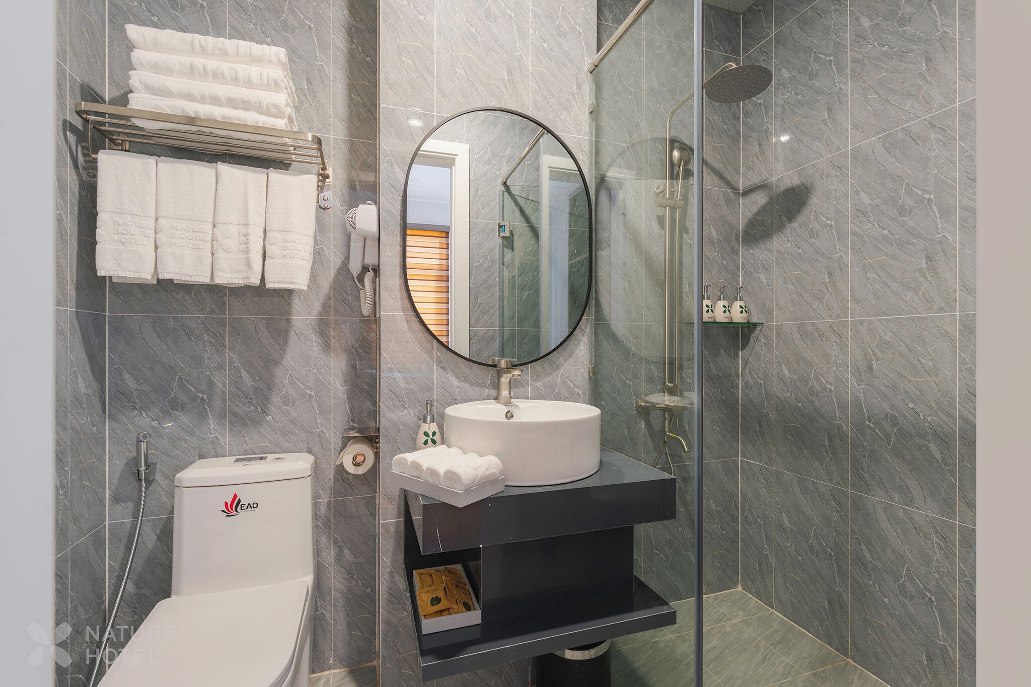 A modern bathroom with a toilet, a sink, a mirror, and a shower.