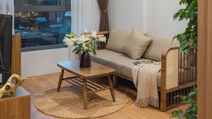 Un salon moderne avec un canapé, une table basse et un téléviseur.