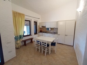 Enjoy meals in this cozy kitchen with a dining table and four chairs, plus a small bench for extra seating.