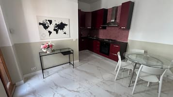 Una cucina moderna con mobili rossi, un piano cottura a gas e una mappa del mondo appesa al muro.