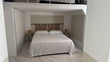 Una camera da letto con un letto, due comodini, una testiera e una finestra.