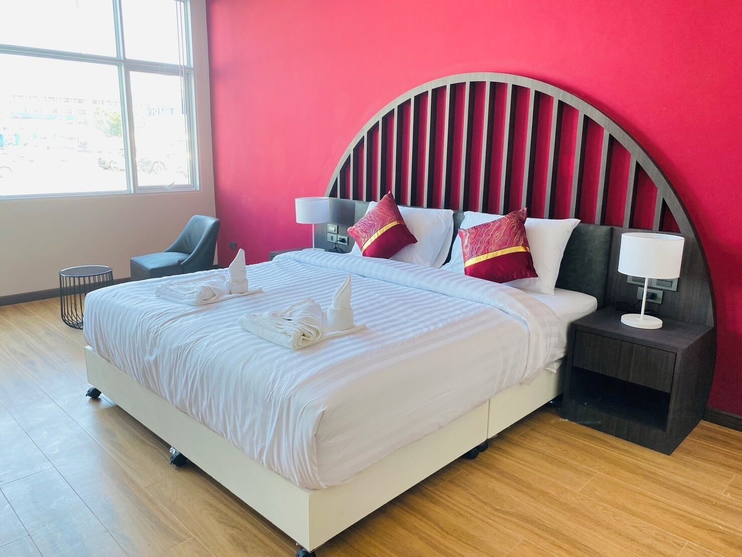Una camera d'albergo con un letto grande, una scrivania, una sedia e una finestra.
