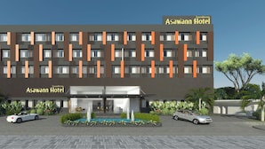 Een modern hotelgebouw met een plat dak, meerdere verdiepingen en een opvallende ingang.