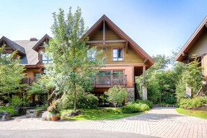 Eine Lodge mit einem zentralen Gebäude, das einen Balkon und eine Steinsockel besitzt.