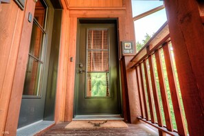 A wooden front door with a window and a mailbox.