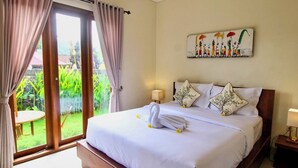 Un dormitorio con cama, cortinas, un cuadro y vistas a la vegetación.