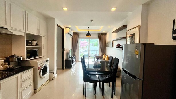 Una cocina moderna con comedor, que incluye lavadora, microondas y refrigerador.