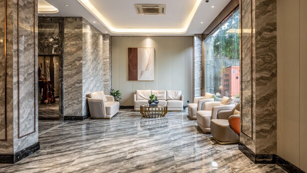 A modern lobby with marble flooring, a central coffee table, and a seating area with sofas and armchairs. - Bole Boutique Hotel, Sihanoukville (Sihanoukville)
