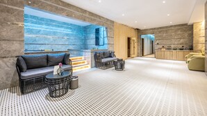 A modern spa area with a stone wall, seating, and a reception desk. - Bole Boutique Hotel, Sihanoukville (Sihanoukville)