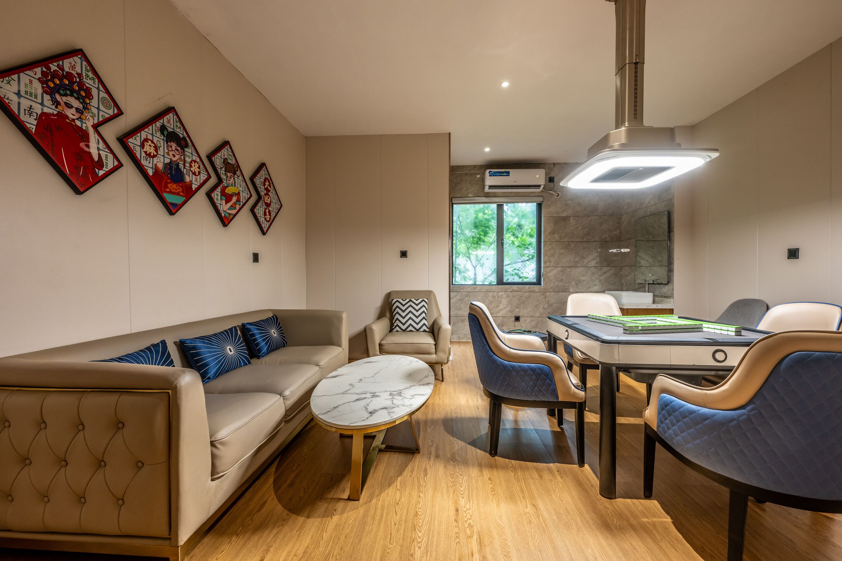 A modern living room with a sofa, chairs, a coffee table, and artwork on the wall.