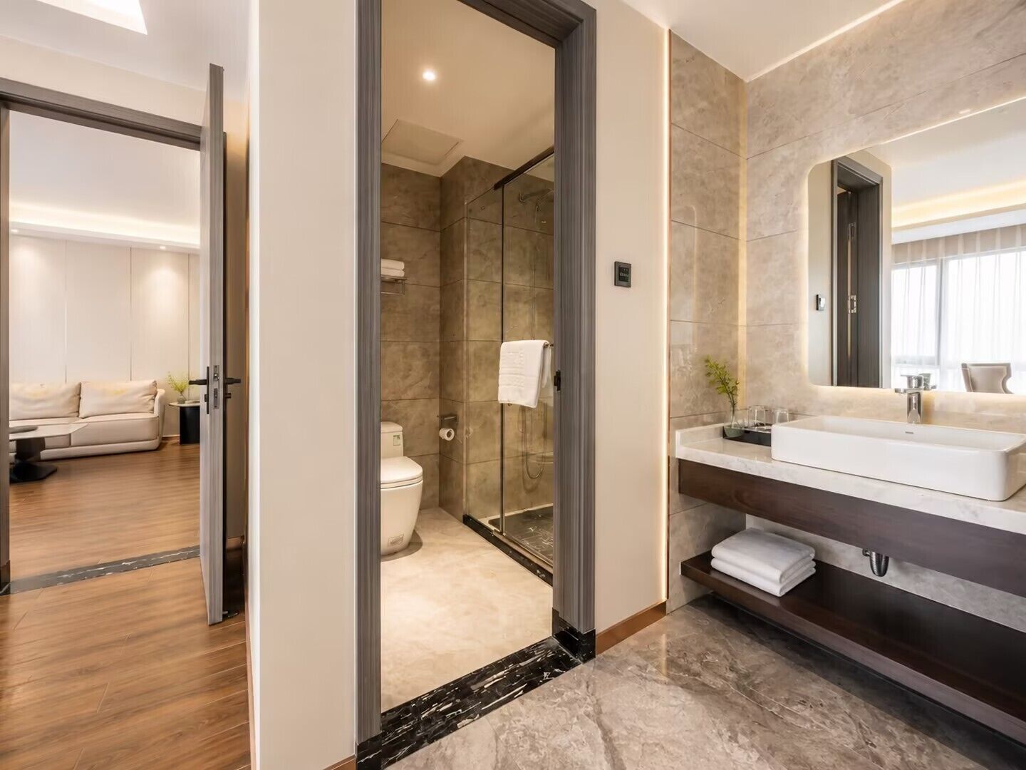 A modern bathroom with a glass shower, a large mirror, and a white sink.