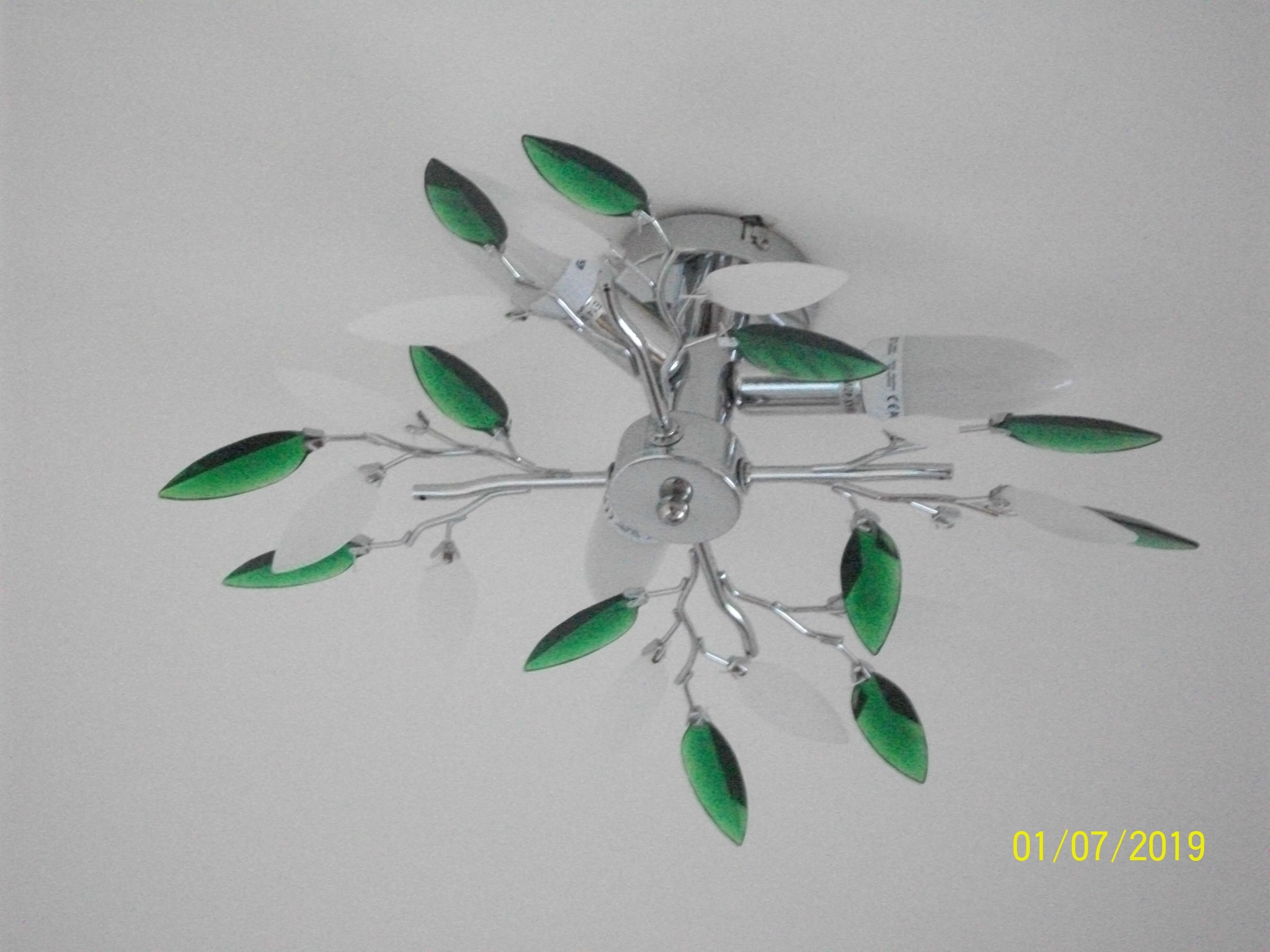 A chandelier with multiple branches and green leaves.