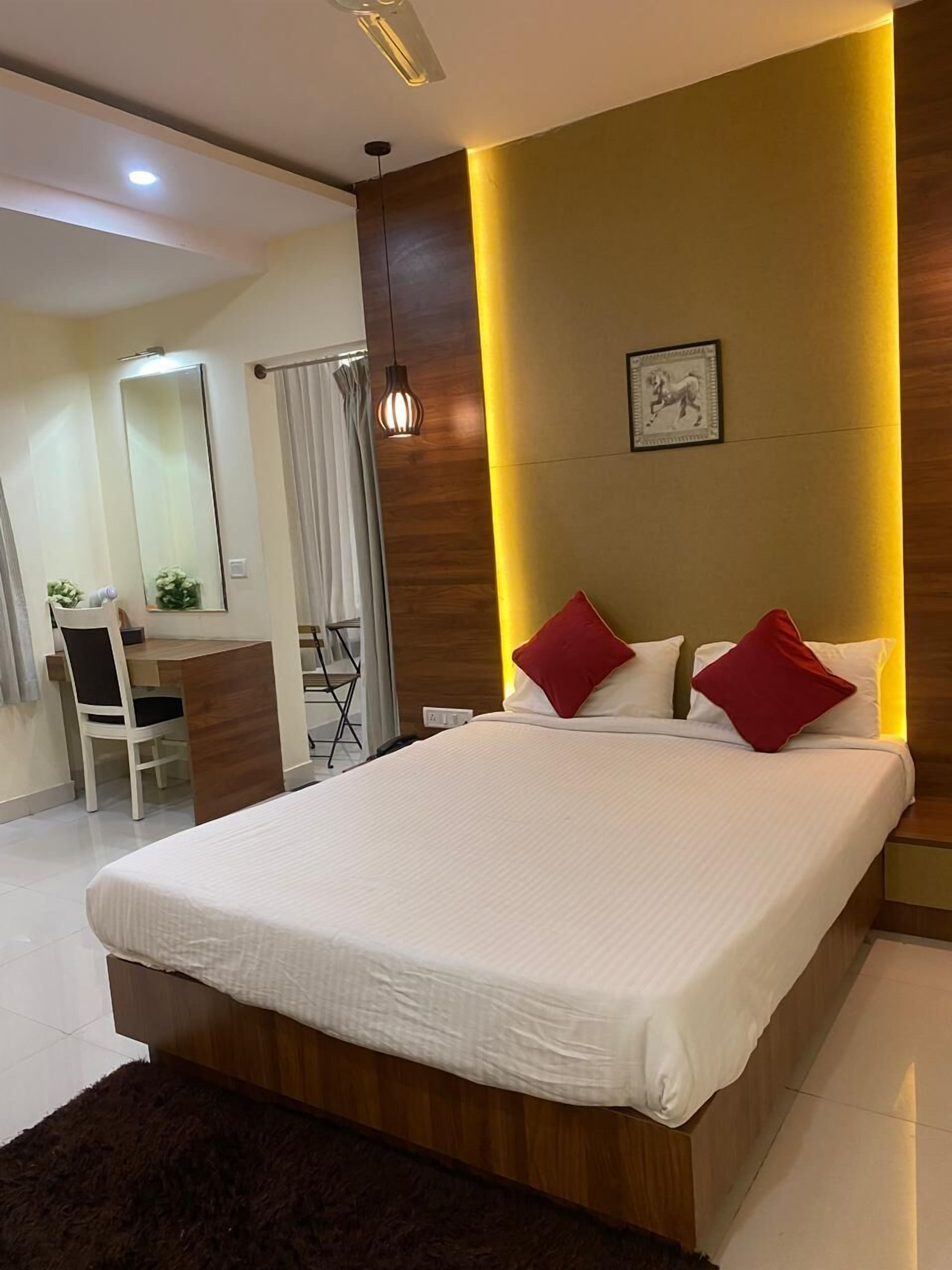 A modern bedroom with a large bed, a desk, and a chair.