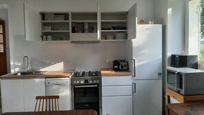 Cocina compacta equipada con lavavajillas, estufa, horno, microondas y un refrigerador pequeño.