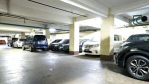 A multi-level parking garage with several cars parked in rows. - OYO 94087 Apartemen 19 Avenue By Rh (Jakarta)