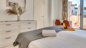 Een hotelkamer met een bed, een bureau, een stoel, een raam met gordijnen en uitzicht op buiten.