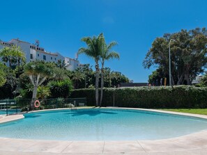 Una piscina rodeada de vegetación y edificios.