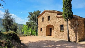 A stone building with a single entrance and windows, surrounded by trees and a clear sky. - More Morrenyà - Garrotxa Country House (Sant Jaume de Llierca)