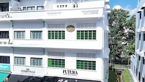 Un immeuble à plusieurs étages dont le rez-de-chaussée abrite une auberge de jeunesse de la chaîne FUTURA.