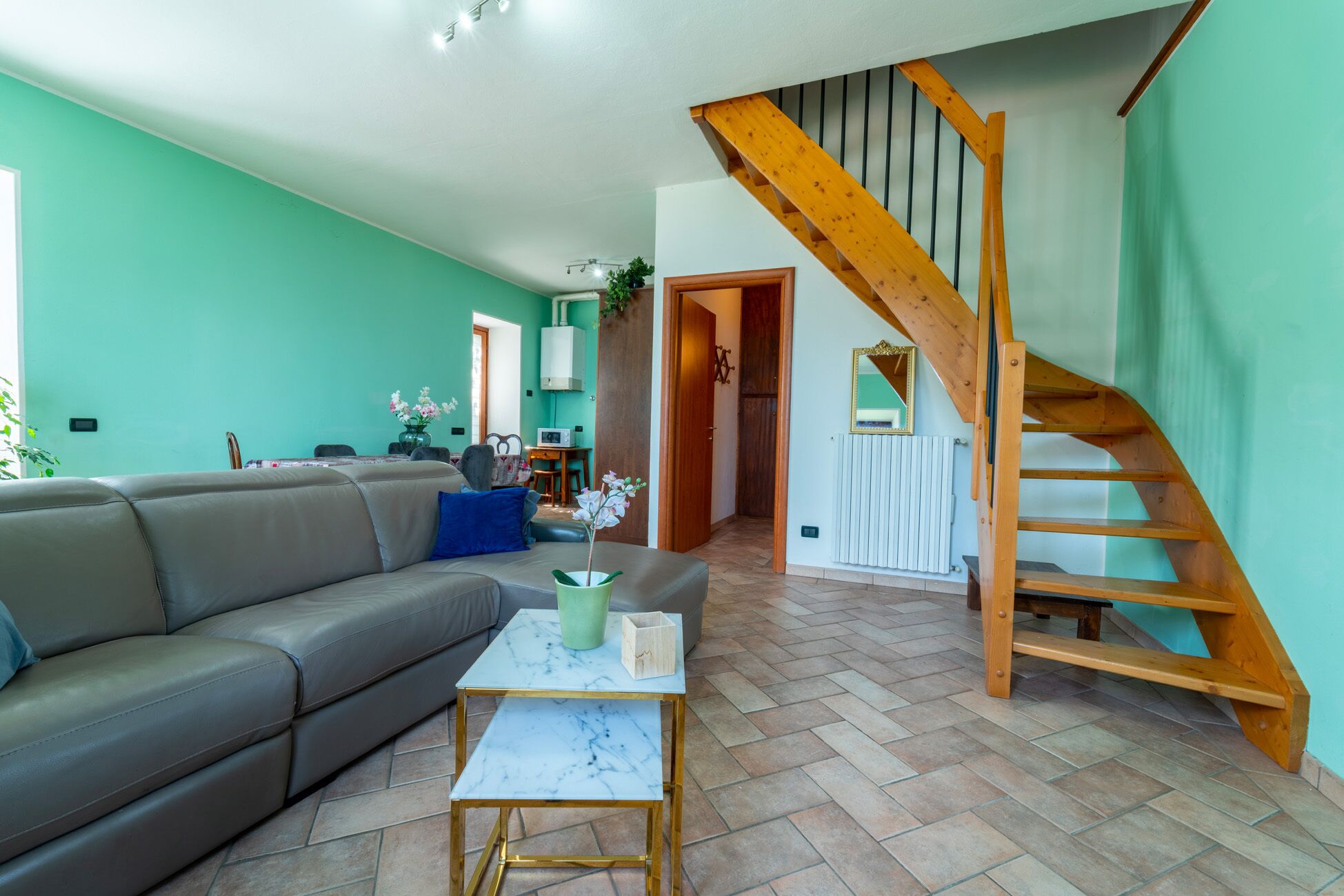 A living room with a sofa, a coffee table, and a wooden staircase.