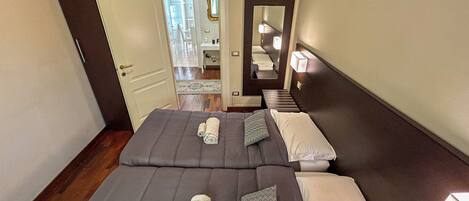 A hotel room with two beds, a mirror, and a door leading to a hallway.