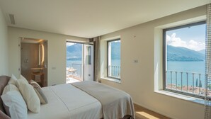Una camera da letto con un letto grande, bagno e balcone con vista sul mare.
