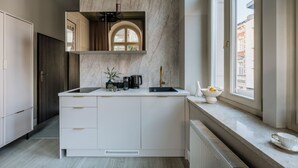 Een moderne keuken met een marmeren achterwand, een inbouwoven en een raam met uitzicht op een stadsbeeld.
