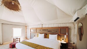 Una stanza con tende, un letto grande, una testiera in legno, lampade ai comodini e un lampadario.