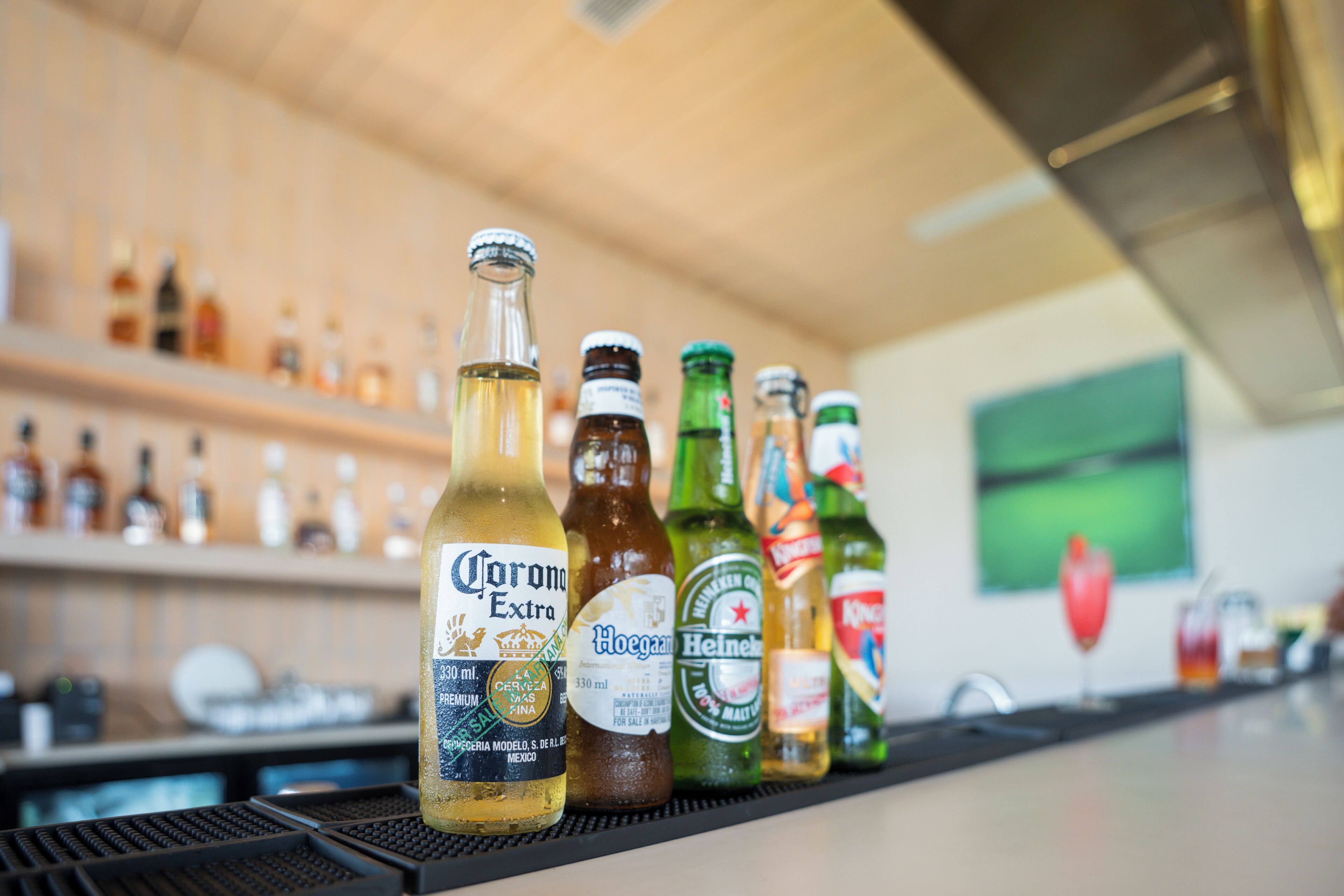 A bar counter with various bottles of beer and liquor.