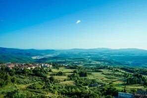 A panoramic view of a town nestled in a valley with rolling hills and a clear blue sky. - Appartamento Pesca Shared Pool (Roccastrada)
