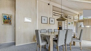 A modern dining area with a round table and six grey upholstered chairs. - Stunning home in Otterup with sauna (Otterup)
