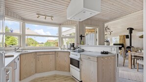 A modern kitchen with large windows, a central island, and a wood-paneled design. - Stunning home in Otterup with sauna (Otterup)