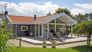 A modern house with a covered patio, large windows, and a red-tiled roof. - Stunning home in Otterup with sauna (Otterup)