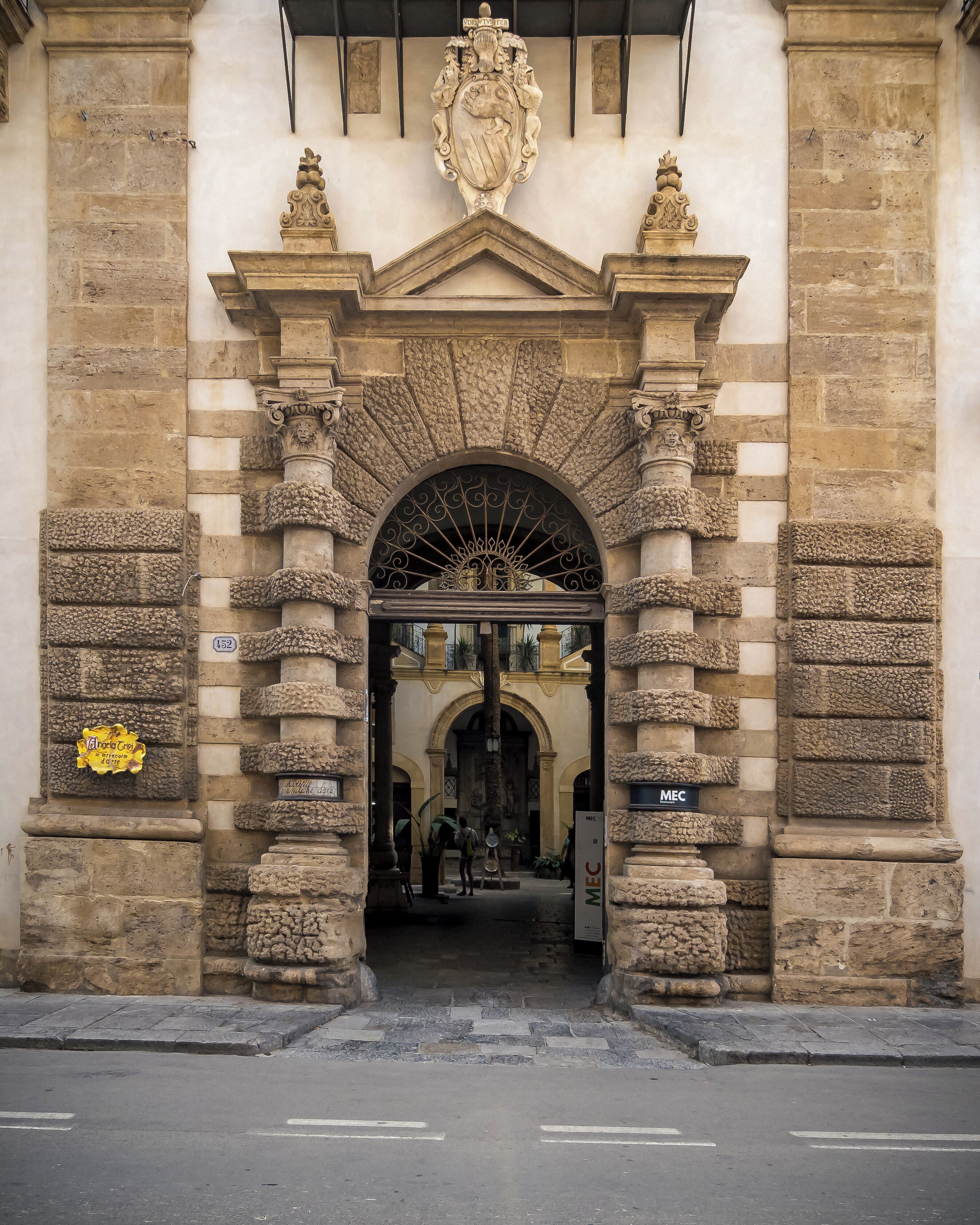 Una entrada de piedra ornamentada con un arco central, flanqueado por columnas y detalles decorativos.