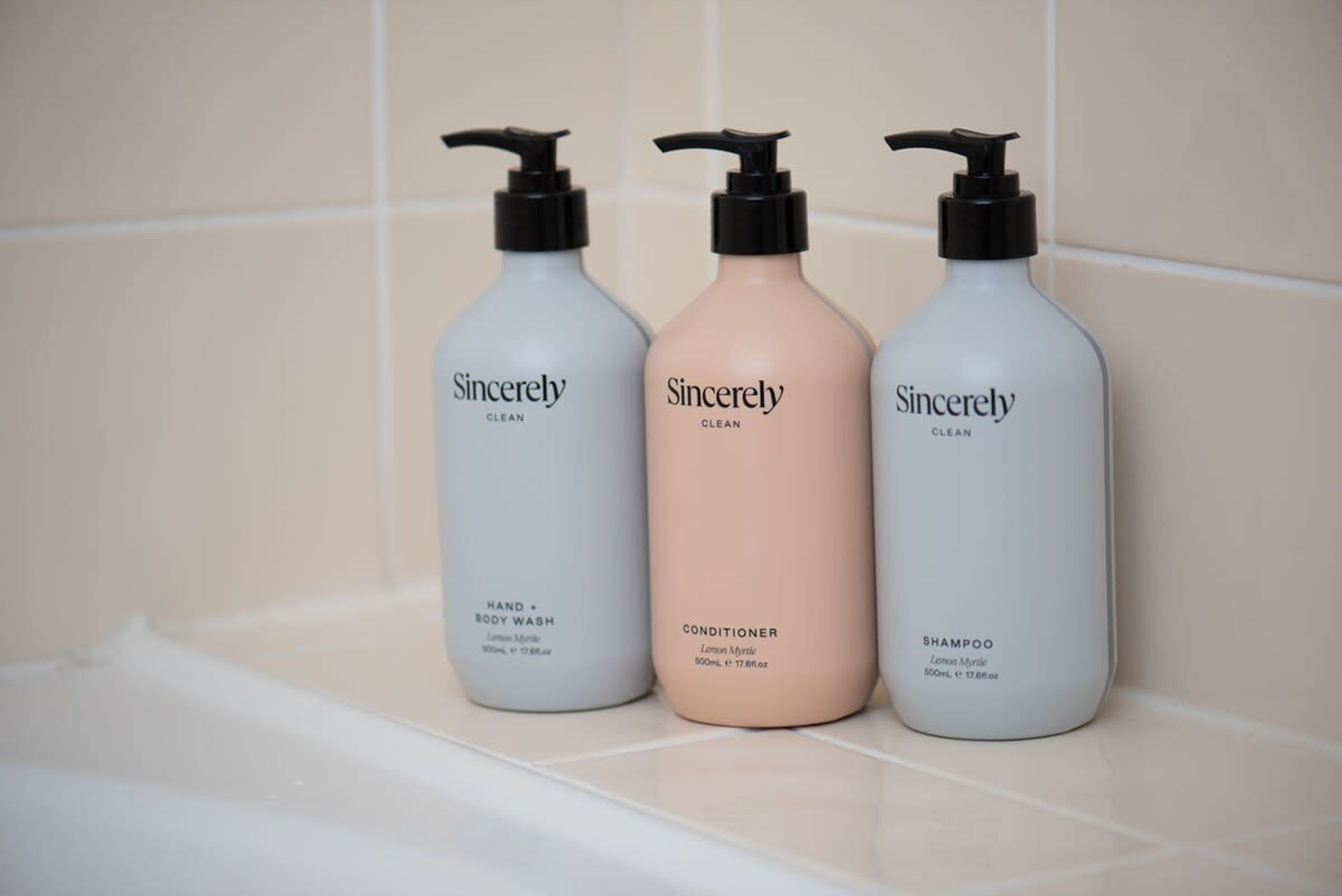 Three bottles of Sincerely Clean products on a tiled surface.