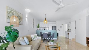 Ein modernes Wohnzimmer mit Sofa, Couchtisch und Essbereich.