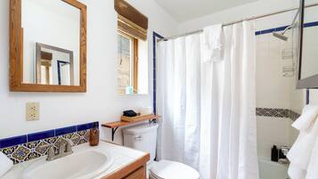 A bathroom with a sink, toilet, and shower area.