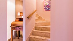 A staircase with a wooden handrail and a lamp on a desk in the adjacent room. - Casa La Buganvilla del Chaparral (Marbella)