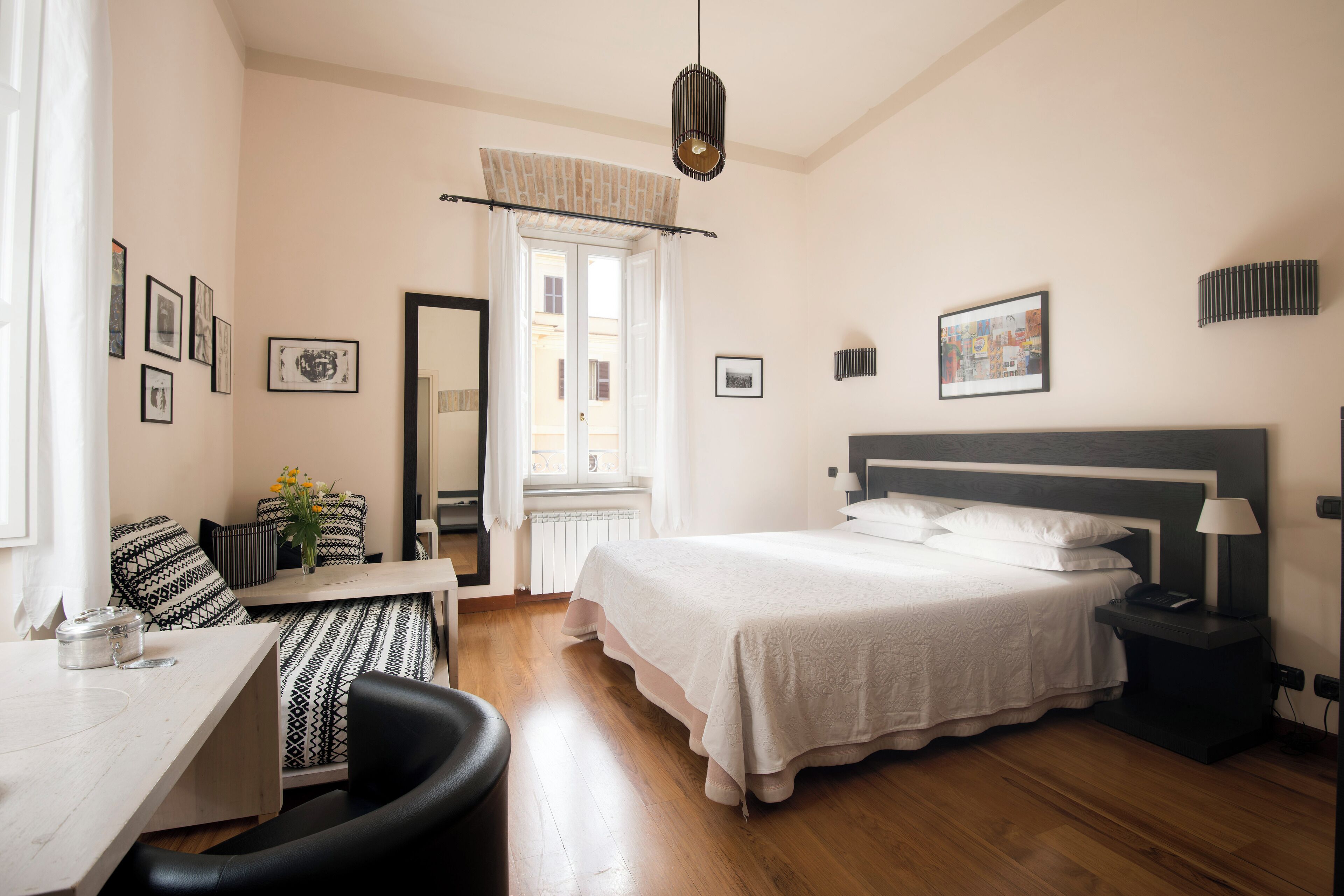 Un dormitorio con cama, mesita de noche, silla y escritorio con silla.