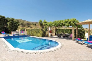 A swimming pool with lounge chairs and a pergola. - Villa Elysium in Kalathos (Rhodes)