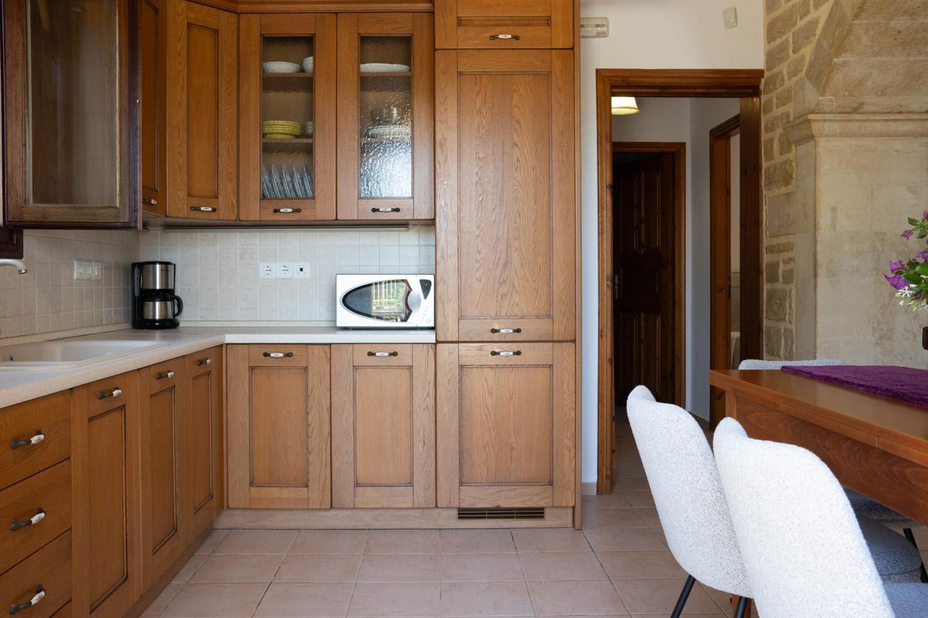 A kitchen with wooden cabinets, a microwave, and a coffee maker.