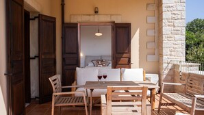 Un patio exterior con muebles de madera, una mesa y un sofá.