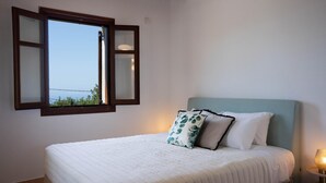 Un dormitorio con cama, ventana con vistas y lámpara de noche.