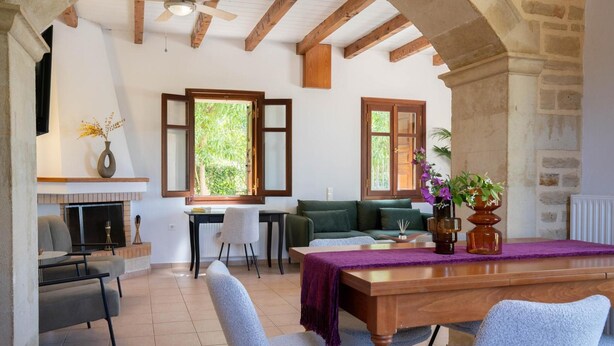 Un amplio espacio de estar con mesa de comedor, sillas, sofá y chimenea.