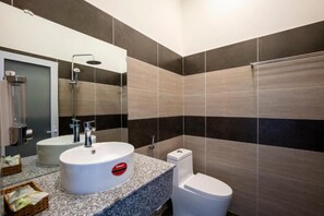 A modern bathroom with a granite countertop, a white sink, a toilet, and a shower. - Phu Quoc Hotel (Phu Quoc)