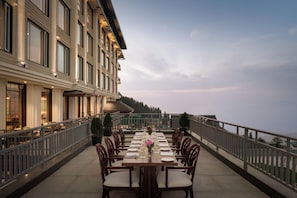 A dining table set for six on an outdoor terrace with a view of the mountains. - Greenberry Resort Narkanda, a member of Radisson Individuals Premier (Kumharsain)