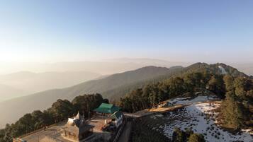 A mountainous landscape with a building featuring a green roof and traditional architecture.