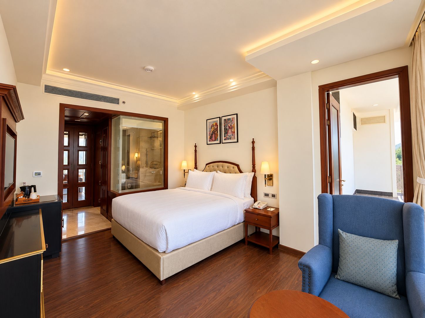 A hotel room with a large bed, a bedside table, a chair, and a view of the outdoors.