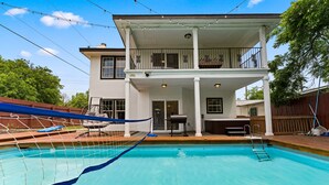 A two-story house with a swimming pool, a covered patio, and a barbecue area. - Modern 5 BR Sleeps 16 with Pool, Spa, Air Hockey, BBQ & Games Near Downtown! (San Antonio)