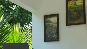 A reception area with a sign that reads "RECEPTION," a framed painting, and a potted plant. - Hotel O Fgh Residence 1 (Bekasi)